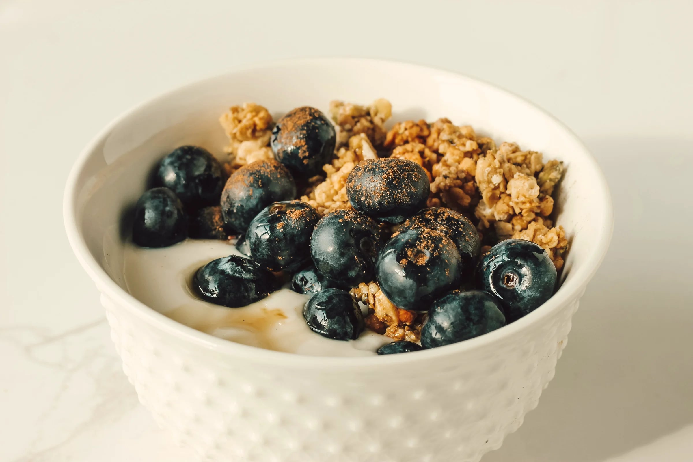 A bowl of yoghurt topped with blueberries and granola