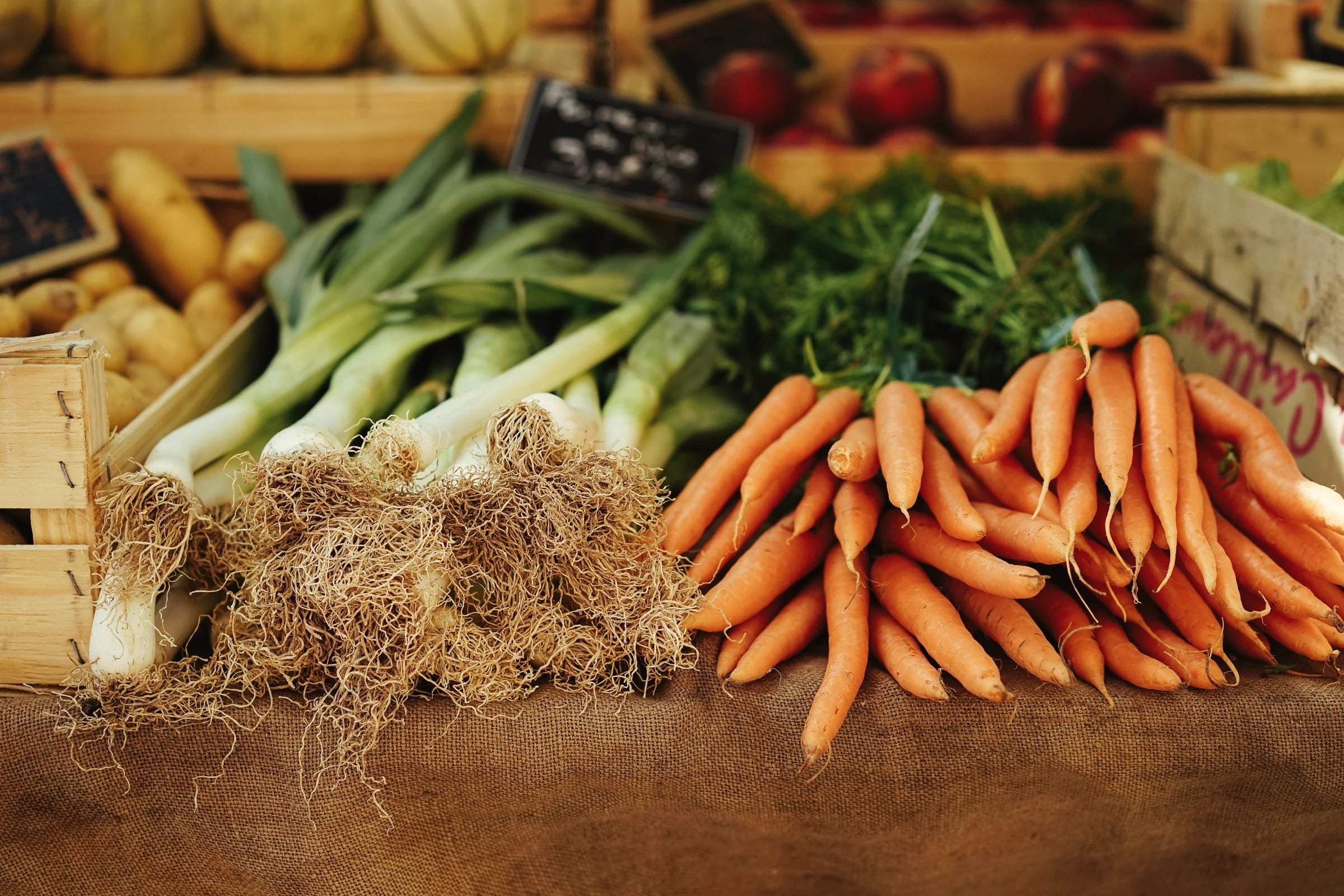 Fresh leeks and carrots at a market stall